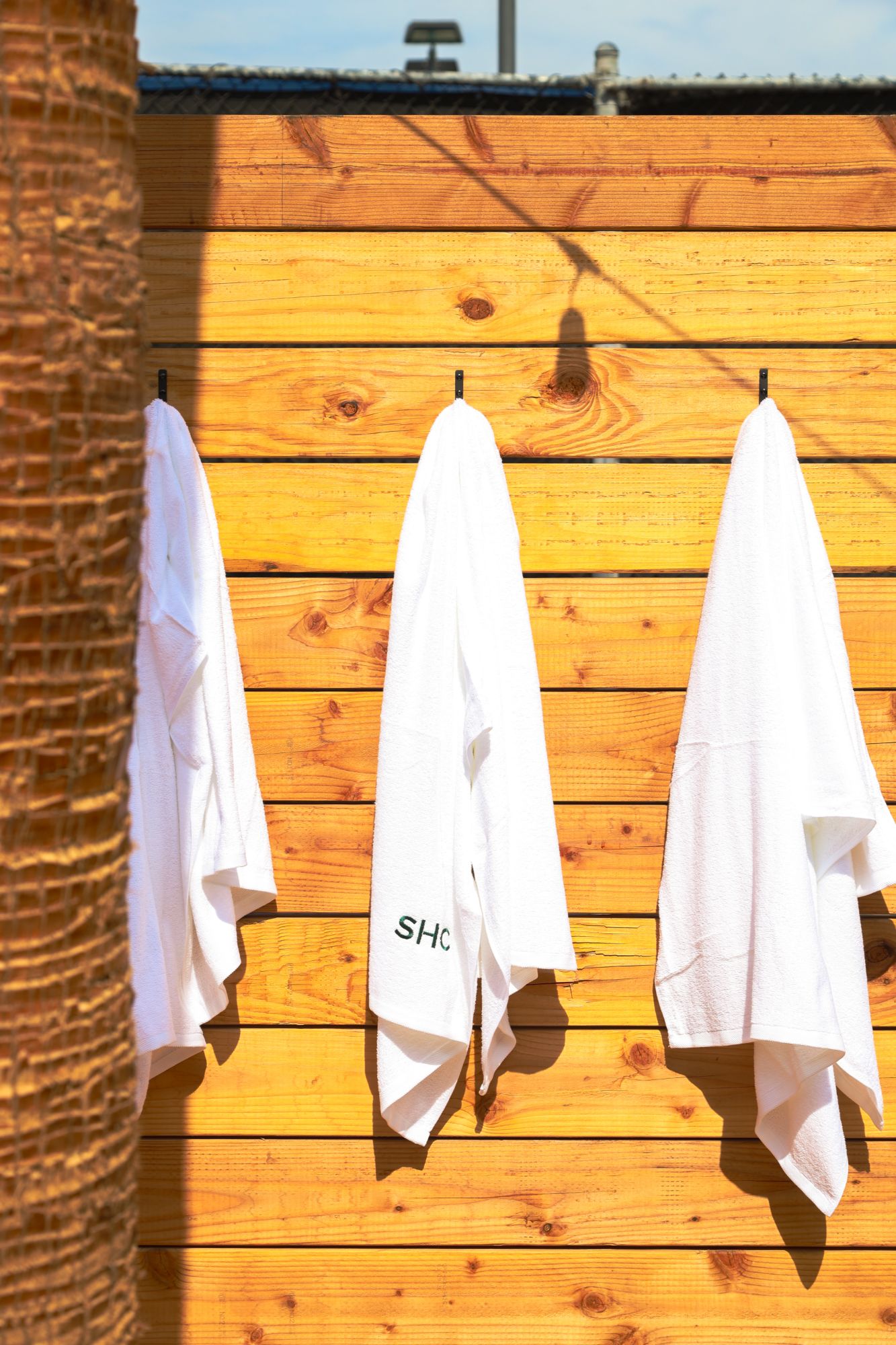 SHC towels hanging on a cedar wall in the sun